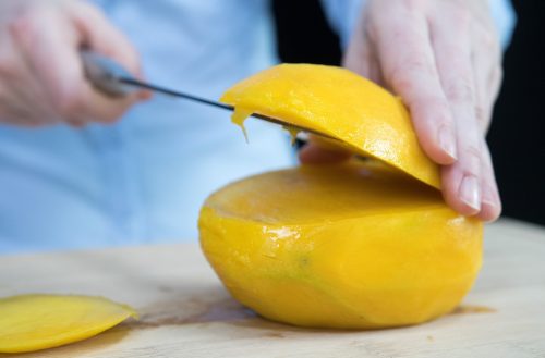 Die Mango auf die nun flache Seite legen. Dann von der oberen, gewölbten Seite eine weitere Scheibe Fruchtfleisch abschneiden. Fotos: Andrea Warnecke/dpa-tmn