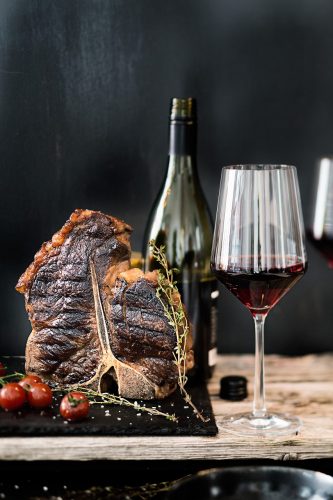 Beim Braten oder Grillen von Fleisch entstehen Röstaromen, die mit den Gerbstoffen eines Rotweins besser harmonieren als mit einem säurehaltigen Weißwein. Foto: Deutsches Weininstitut