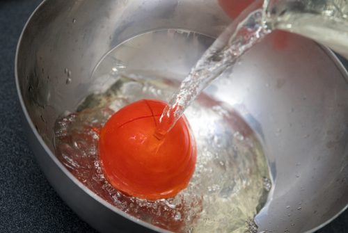 Die Tomate in eine Schüssel legen und mit kochendem Wasser übergießen. Fotos: Andrea Warnecke/dpa-tmn