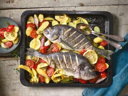 Auch Fisch kann mit Gemüse, Zwiebeln und Knoblauch zusammen im Ofen gegart werden. Foto: Klaus Arras/Gräfe und Unzer